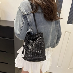 Sac seau matelassé noir à cordon avec une fine bandoulière en cuir élégante pour femmes