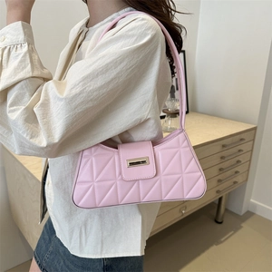 Bolso de hombro acolchado rosa con hebilla metálica mostrado sobre una modelo