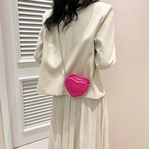 Petit sac bandoulière rose en forme de cœur avec chaîne argentée vue de dos sur un mannequin