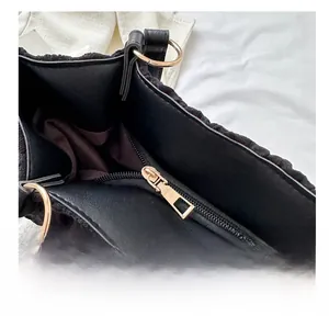 Close-up of smooth golden metal zipper and textured black fabric on tote bag