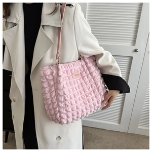 Detalle de bolso tote rosa con textura de burbujas y etiqueta de cuero a la moda