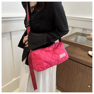 Detail of rose red quilted nylon crossbody bag with fashion label and adjustable strap