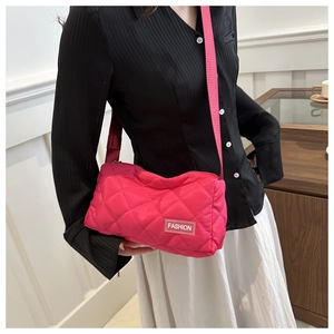 Macro detail of fuchsia quilted rhombus crossbody bag with white fashion logo tag