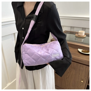 Close-up of light purple quilted bucket bag with adjustable strap and fashion label