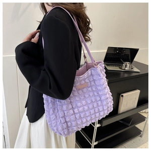 Detalle de bolso tote lila de tela palomita con un pequeño parche de moda cuadrado