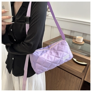 Detailed macro view of purple quilted rhombic texture and white Fashion tag on tote bag