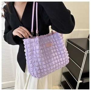 Detail of purple popcorn fabric tote bag with fashion tag and leather shoulder strap