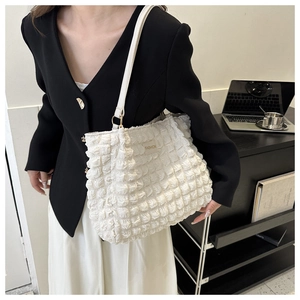 Detalle del tejido tipo gofre blanco y etiqueta de cuero de moda en el bolso de mano