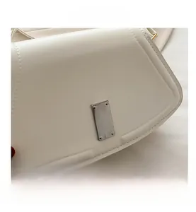 Detailansicht der weißen Ledertasche mit silberner Schnalle und feiner Ledertextur