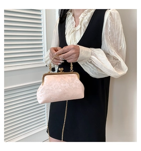 Close-up of pink jacquard qipao bag with gold kiss-lock frame and chain strap