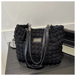 Detalle del bolso tote negro con tejido de burbujas y parche de cuero FASHION