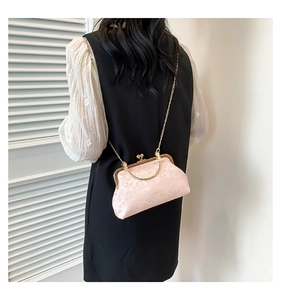 Detail of light pink floral jacquard handbag with vintage gold metal frame and handle