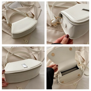 Detailansicht der weißen halbkreisförmigen Ledertasche mit Innenfächern und Silberbeschlägen
