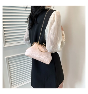 Detailed view of pink floral silk evening bag with vintage gold chain strap and metal clasp