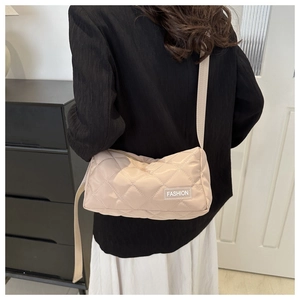 Detail of beige quilted crossbody bag with FASHION label and adjustable strap