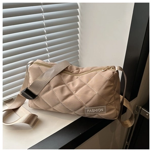 Detail of beige quilted tote bag with diamond pattern and transparent fashion label