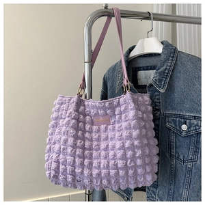 Detail of lavender popcorn textured tote bag hanging with stylish denim jacket