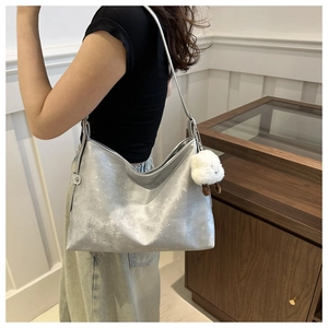 Silver metallic tote bag with sheep pendant showing large capacity on model