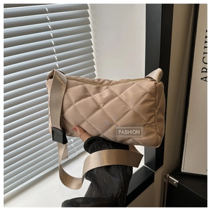 Close-up of beige quilted tote bag featuring diamond stitching and fashion label