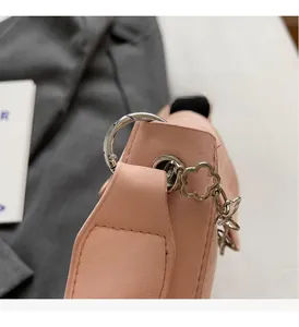 Detailed close-up of pink leather bag featuring silver flower chain and metallic ring