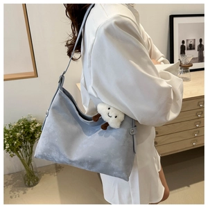 Detail view of large capacity light blue suede tote bag with rivets and plush cloud charm