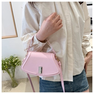 Detailaufnahme einer rosa Lederhandtasche in Muschelform mit silbernem Metallschloss