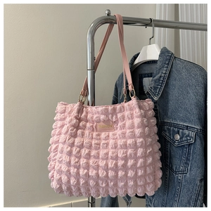 Detailed view of pink puffy bubble tote bag with leather strap and fashion label