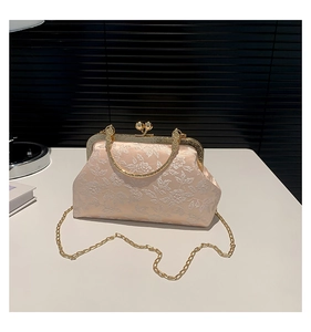 Macro view of champagne floral jacquard fabric and vintage pearl clasp on the handbag