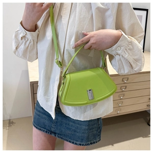 Detailansicht einer hellgrünen Ledertasche mit Silber-Drehverschluss an einem Model
