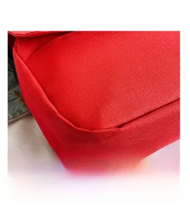 Macro shot of durable red canvas crossbody bag corner showing fine stitching detail