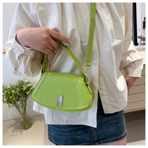 Grüne Handtasche in Muschelform mit Silber-Schnalle getragen von einem Model