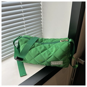 Close-up of green quilted nylon tote bag with rhombus pattern and Fashion label detail