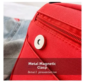 Detail of silver magnetic buckle and resin zipper on red canvas messenger bag