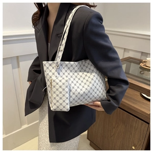 Detailed view of monogram tote bag with matching mini pouch on navy blazer