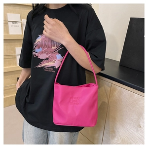 Detail van roze nylon schoudertas met 'pretty and liberty' borduursel op de stof