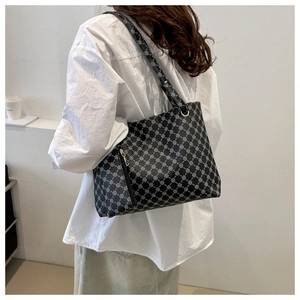 Detail of vintage black tote bag with white geometric chain pattern and spacious interior