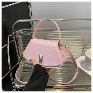 Rosafarbene Trapez-Handtasche aus Leder mit Metallschnalle in modernem urbanem Café-Ambiente