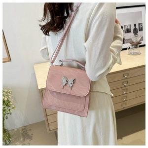Detail of soft pink backpack featuring a silver butterfly buckle and marble texture