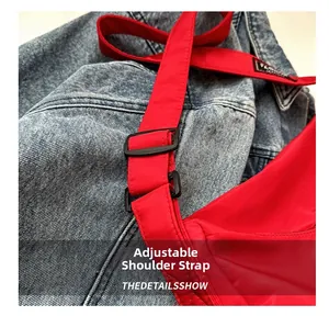 Détail de la bandoulière réglable en nylon rouge avec boucle noire sur un sac décontracté