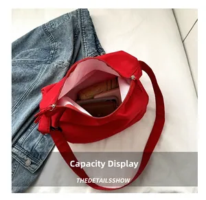 Vue détaillée du sac bandoulière rouge en oxford montrant sa grande capacité interne