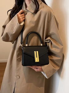 Elegant black leather handbag with gold metal lock buckle and adjustable shoulder strap