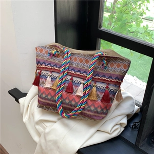Ethnic style large tote bag with colorful woven patterns and vibrant tassel decorations