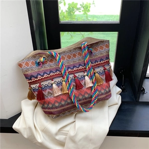 Bohemian woven tote bag with colorful geometric patterns and decorative tassels