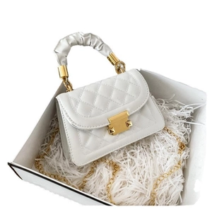 White quilted shoulder bag with ruffles handle and gold buckle in a white gift box