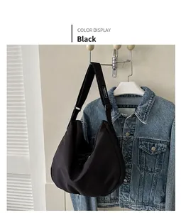 Gros plan sur le sac hobo en nylon noir imperméable avec bandoulière réglable et détails nets