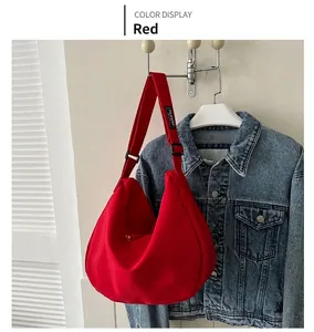 Détail du sac hobo rouge en nylon avec bandoulière réglable et étiquette mode au mur