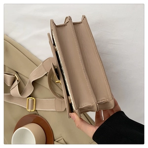 Detail view of the multi-layer accordion structure and woven texture of the beige bag