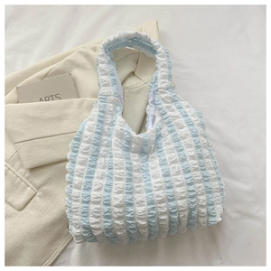 Detail of light blue and white striped puffy tote bag with textured bubble fabric