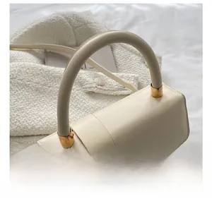 Detailed shot of comfortable cream white leather handle with gold metal hardware