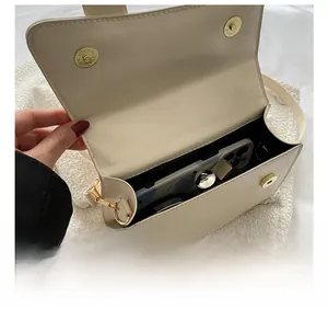 Detail view of the spacious cream faux leather handbag interior with magnetic buckles